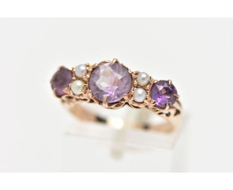 A YELLOW METAL GEM SET RING, designed with three circular cut amethysts, each interspaced with four seed pearls, openwork hea