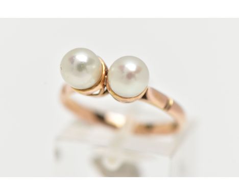 A YELLOW METAL CULTURED PEARL RING, designed with two white cultured pearls, measuring approximately 6.0mm, each set within a