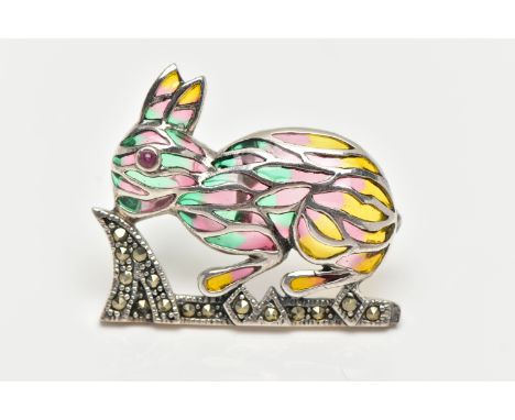A WHITE METAL PLIQUE A JOUR BROOCH, in the form of a rabbit, set with a red cabochon eye, decorated with red, green and yello
