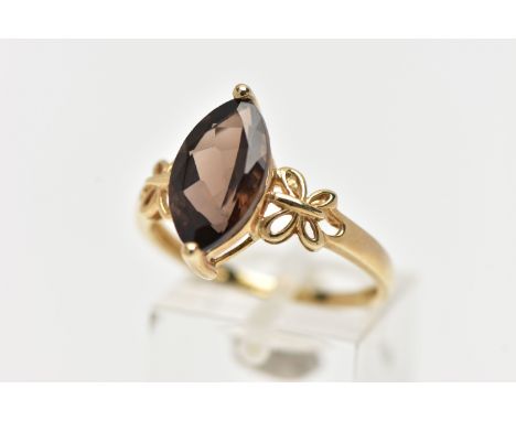 A 9CT YELLOW GOLD SMOKEY QUARTZ DRESS RING, set with a marquise cut smokey quartz, to the open work foliate shoulders, hallma