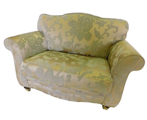 A small gold and silver Damask upholstered sofa, with a padded back and seat, on square tapering legs, with castors, 134cm wi