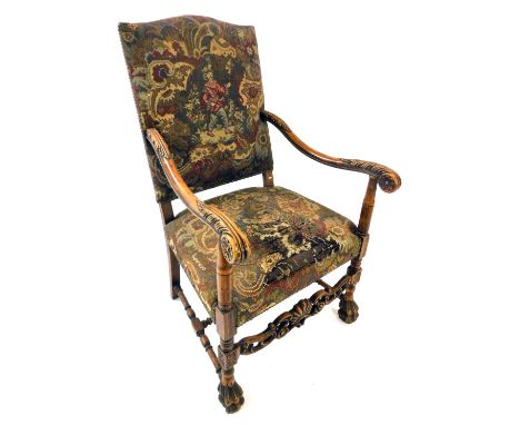 A late 19th/early 20thC Continental walnut open armchair, upholstered in tapestry style fabric, the shaped arms carved with l