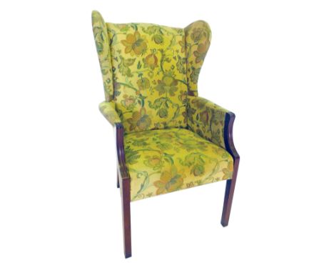 A winged back chair, in tapestry upholstery, with square mahogany legs.  