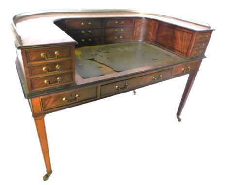 A late 19thC mahogany and ebonised Carlton House desk, the raised top with a pierced brass gallery and an arrangement of twel