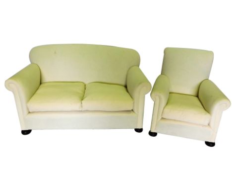 A three piece suite, comprising two seat sofa, and two armchairs, upholstered in white calico, on bun feet, the sofa 140cm wi