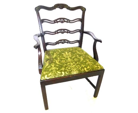 A late 19th/early 20thC mahogany elbow chair, the pierced ladder back carved with acanthus, the drop in seat upholstered in g
