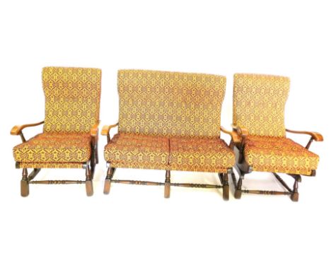 A late 20thC stained beech three piece cottage suite, comprising two seat sofa, armchair, and a rocking chair, upholstered in