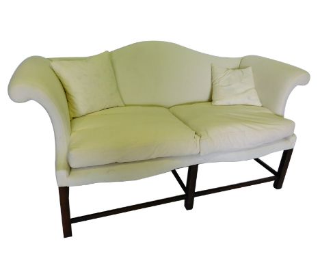 A mahogany sofa in George III style, with a camel shaped back, scrolling arms, loose cushions on square section legs with str