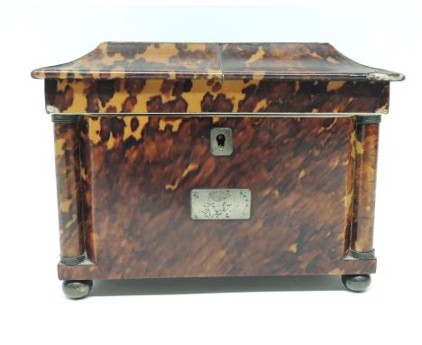 An early Victorian tortoiseshell tea caddy of sarcophagus form, the lid inlaid with mother of pearl, the body with rounded pi