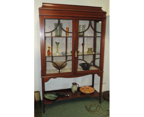 An early 20th century crossbanded and inlaid mahogany display cabinet, having pagoda type top, pair of astragal glazed doors 