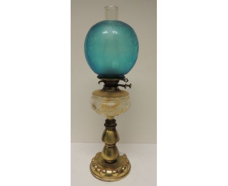 A late 19th/early 20th Century oil lamp having turquoise glass shade with etched decoration, clear cut glass bowl on brass pe