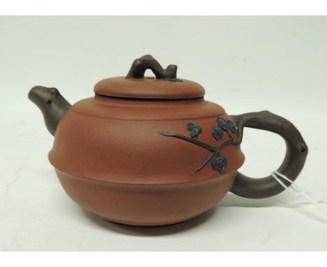 A Chinese Yixing teapot, the red stoneware globular shaped pot with applied prunus finial, handle and spout, impressed seal m