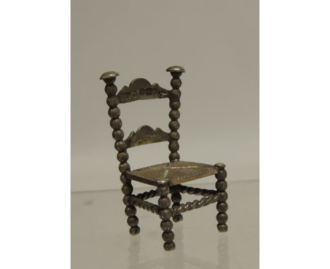 A 19th Century Continental miniature silver country style chair with ladder back, bobbin supports and rush seat, import marks