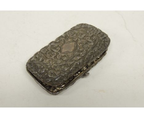 A late 19th Century Indian silver cigarette case of rectangular form with heavily embossed decoration of flowerheads and scro