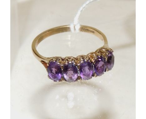 A 9ct gold dress ring, set with five oval faceted mauve glass stones, size R.