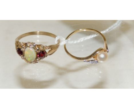 A 9ct gold dress ring of cross-over style, set with a central cultured pearl, and with a tiny diamond either side, size P; an