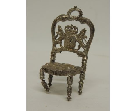 A 19th Century Continental silver miniature throne chair, the back cast with coat of arms supported by lions, the seat emboss