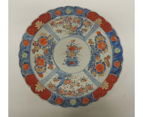 A Japanese Arita Imari charger painted in traditional palette with panels of prunus blossom and chrysanthemums divided with n