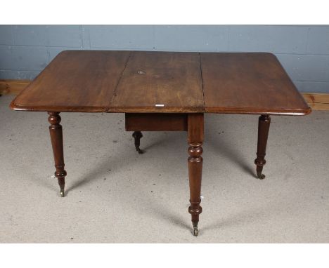 Victorian mahogany drop leaf table, the round cornered top raised on turned legs and brass castors, approx. 130cm long when o