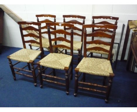 A SET OF SIX OAK FRAMED RUSH SEATED LADDER BACK CHAIRS