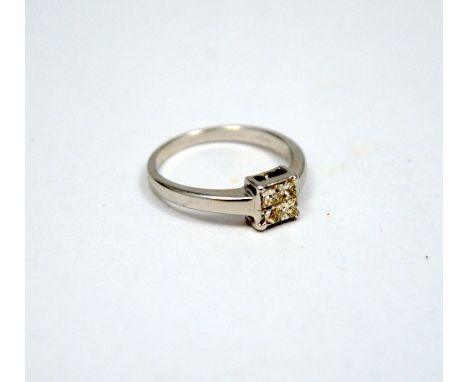 AN 18CT GOLD DIAMOND RING, comprising of four square cut diamonds to form a larger square shape stone to the plain tapered ba