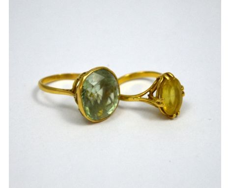 TWO DRESS RINGS, the first a faceted green quartz together with an oval faceted citrine ring, both stamped 18ct, ring sizes M