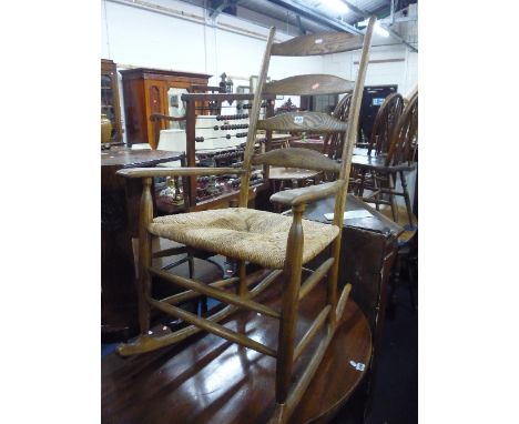 A LADDER BACK ROCKING CHAIR, with rush seat