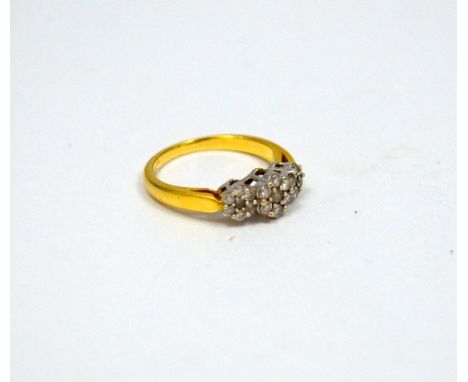A DIAMOND RING, comprising of three daisy shape clusters to the plain tapered band, stamped 18ct, ring size M