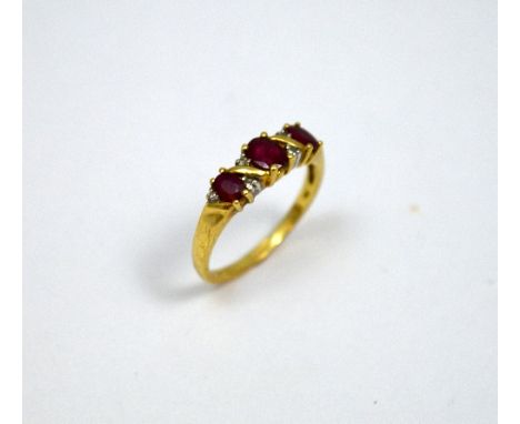 A 9CT GOLD RUBY AND DIAMOND RING, the three oval shape rubies with single diamond accents, hallmarks rubbed, ring size N