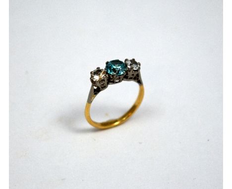 AN 18CT GOLD ZIRCON RING, the blue zircon flanked by clear zircon stones to the bi-coloured tapered shank, stamped 18ct, ring