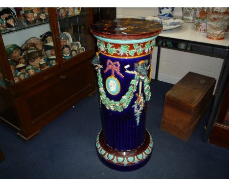 A LATE 19TH CENTURY WEDGWOOD MAJOLICA CIRCULAR FLUTED JARDINIERE STAND, modelled with vineous band above foliate swags, Leopa