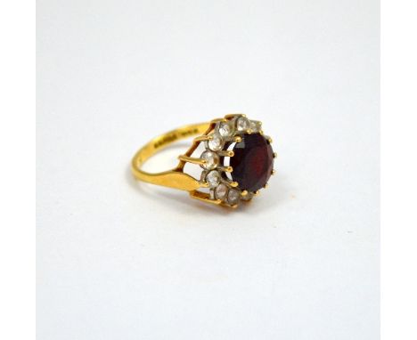 A 9CT GOLD DRESS RING, with central garnet within a surround of paste to the plain tapered sides, hallmarks for London, ring 