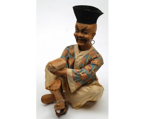 An early 20th century composition clockwork  Nodding Chinaman advertising automaton:, sitting cross legged, advertising tea, 