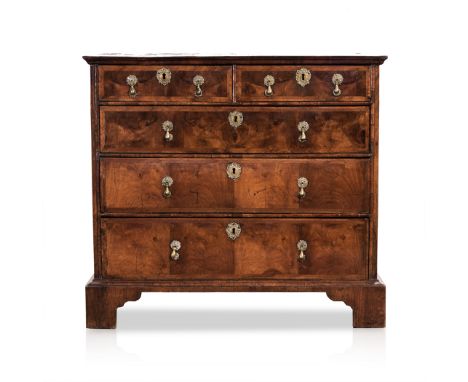 A GEORGE III WALNUT CHEST OF DRAWERS the rectangular quarter veneered and cross banded top above a pair of short drawers, thr
