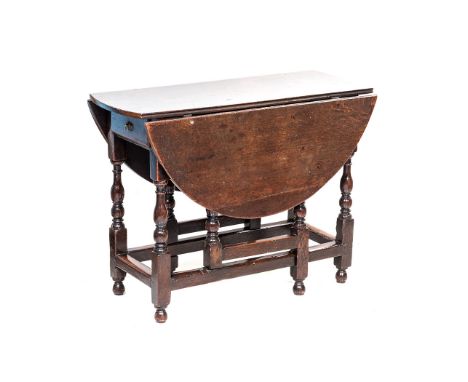 AN OAK GATE LEG TABLE, EARLY 19TH CENTURY the hinged oval top above a short frieze drawer, on upturned baluster supports, on 