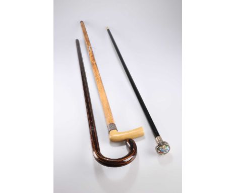 THREE WALKING CANES including an ebonised cane with Continental silver and enamel box-handle; a silver-collared cane with fau