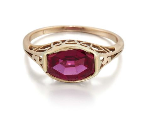 AN ART DECO SYNTHETIC RUBY RING  an octagonal-cut synthetic ruby in a bezel setting, to fancy pierced angular shoulders. Unma