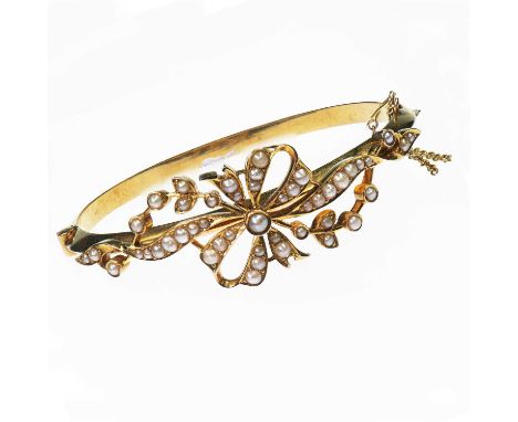 A LATE 19TH CENTURY SEED PEARL HINGE OPENING BANGLE a laurel tied bow motif set with seed pearls, to a plain knife-edge hinge