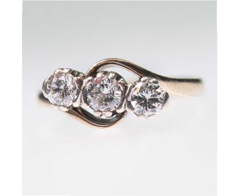 A 9 CARAT GOLD DIAMOND THREE STONE RING round brilliant-cut diamonds to bypass scroll shoulders. Estimated total diamond weig