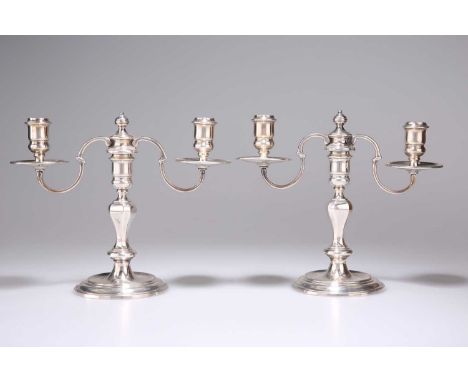 A PAIR OF SILVER-PLATED TWO-LIGHT CANDELABRA by Garrard &amp; Co, each with faceted knopped stem. (2) 18.5cm high