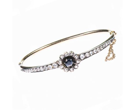 A LATE 19TH CENTURY SAPPHIRE AND DIAMOND HINGE OPENING BANGLE a round-cut sapphire within a flower head cluster of rose-cut d