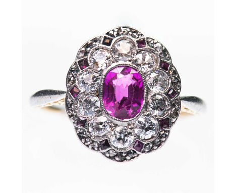 A RUBY AND DIAMOND CLUSTER RING an oval-cut ruby within a fancy milgrain border of old-cut diamonds and rubies, to scroll eng