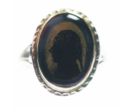 A SILHOUETTE PORTRAIT RING depicting the profile of an 18th Century gentleman on a gilt ground, to forked shoulders. Unmarked