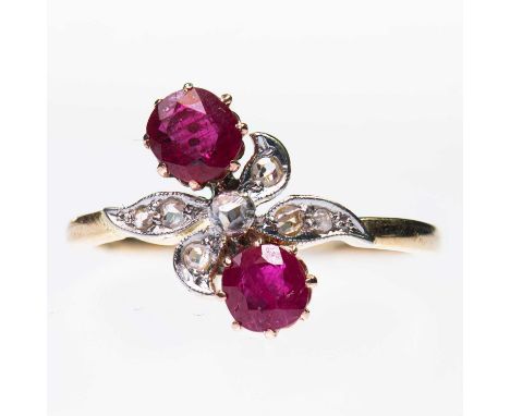 A RUBY AND DIAMOND CROSSOVER RING two cushion-cut rubies to milgrain rose-cut diamond-set scroll shoulders. Dutch '585' mark,
