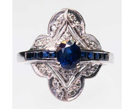 A SAPPHIRE AND DIAMOND CLUSTER RING an oval-cut sapphire spaced by channel-set calibré-cut sapphires and within a fancy pierc