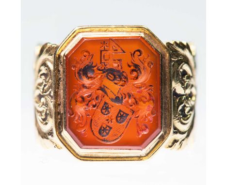 A CARNELIAN INTAGLIO SIGNET RING an octagonal carnelian depicting a crest to fancy broad foliate shoulders. Unmarked, ring si