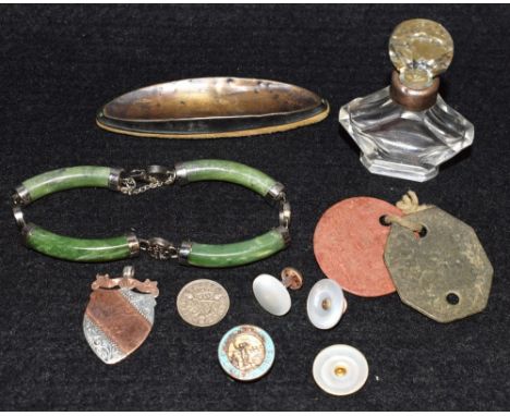 An Art Deco miniature silver mounted clear glass scent bottle; a Victorian silver shield shaped fob; a Chinese jade type brac