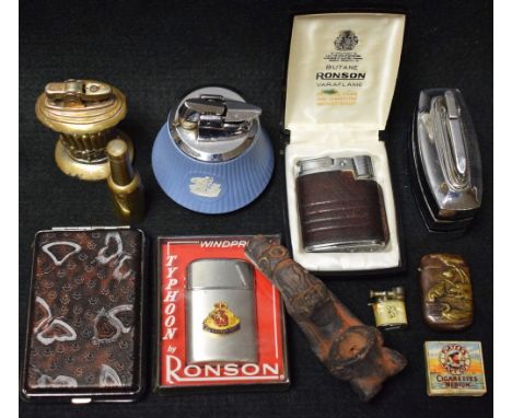 A Ronson pocket cigarette lighter, boxed; other cigarette lighters and cases; a terracotta tribal art type pipe; a brass vest