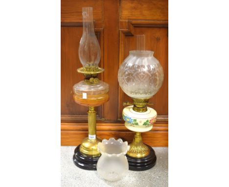 An early 20th century oil lamp smoked glass reservoir, fluted brass column, c.1900;   another, milk glass reservoir (2) 