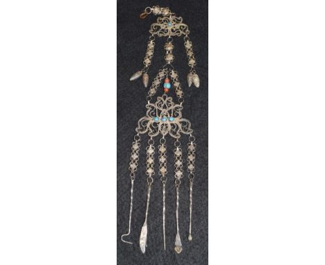 An Indian white metal turquoise and coral beaded scrolling chatelaine, suspending five tools including pick,knife, bradawl et